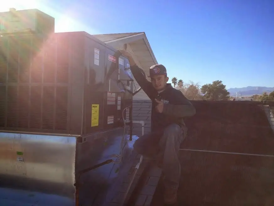 HVAC technician performing AC Tune-Up on a rooftop unit in Wheaton
